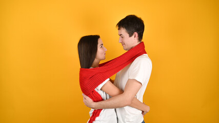 Cuddling young couple, on a yellow background