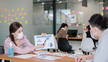 business worker meeting and brainstorm for startup new business. man and woman wear protective face mask in new normal office preventing coronavirus COVID-19 spreading. New normal business concept.