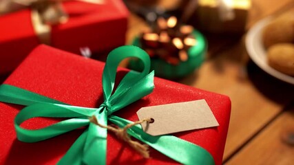 holidays, new year and christmas concept - hands writing receiver's name christmas gift on tag over snow