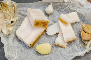 Raw chopped pork lard with meat on a gray background for copy space. A large chunk of fresh fat. Ukrainian lard, traditional food.
