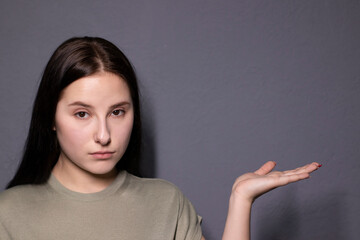 emotional portrait of charming brunette woman in marsh color t-shirt on grey wall background. actress acting, emotion