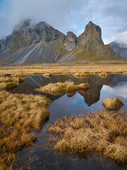 Mount Eystrahorn in golden autumn light. Small pond in foreground. East Iceland.