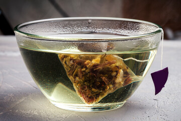 Glass bowl of healthy herbal tea with mint, hibiscus, dried roses and chamomile flowers