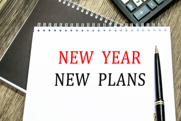 NEW YEAR NEW PLANS. THE TEXT IS WRITTEN IN A NOTEBOOK.