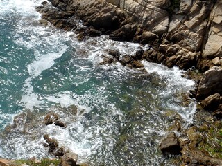 Top view of a small bay and roaring waves.