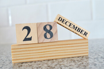 December 28, Cover design with number cube on a white background and granite table.