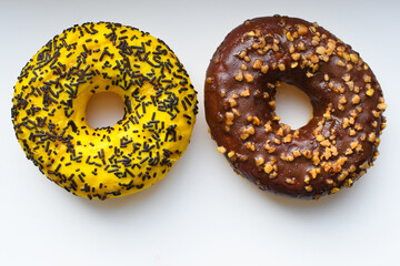 Close-up of two bright, tasty yellow donut with chocolate splashes on a white background