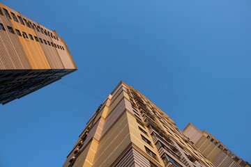 Bottom view of the corner buildings against the blue sky.