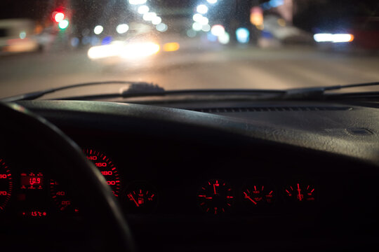 Car Dashboard With Red Light In The Dark In Motion, Photo From Inside