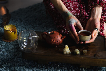 A girl performs a traditional tea ceremony. Chinese puer tea served on a wooden table surrounded by candles