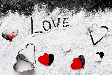 White and red Heart shapes different size made of flour on dark board or table, top view....