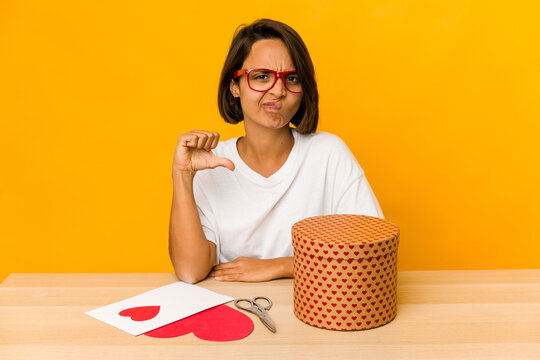 Young Hispanic Woman Preparing A Valentine Gift Isolated Showing A Dislike Gesture, Thumbs Down. Disagreement Concept.