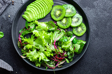 kiwi avocado green fresh salad mix leaves ready to eat on the table meal snack outdoor top view...