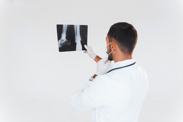 Medic with x-ray. Young handsome man standing indoors against white background