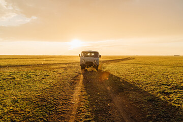Adventure spirit. Old post soviet off-road vehicle car UAZ bus rides on a country road.  Warm...