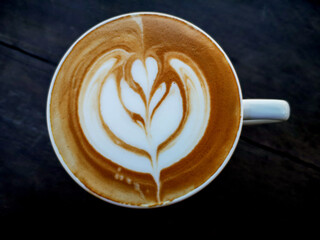 Close up white cup of latte coffee on  wooden table. Hot coffee on a cup.