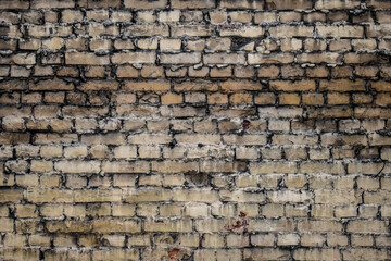 Grunge texture of an old brick wall. Background from old brown bricks. uneven texture of weathered bricks. Brick and plaster on city wall. Noise and grain
