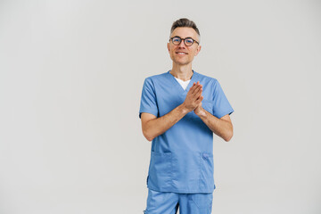 Happy white-haired medical doctor smiling and holding palms together