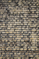 Grunge texture of an old brick wall. Background from old brown bricks. uneven texture of weathered bricks. Brick and plaster on city wall. Noise and grain