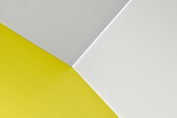 Abstract graphic background in yellow and gray colors. Straight lines on the wall, corner with three edges. three-dimensional texture. Color of the year illuminating 13-0647 and Ultimate Gray 17-5104.