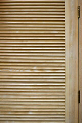 Wooden shutters. Window with wooden doors to protect from sunlight. Background with textured narrow boards. Modern shutters made of natural wood. Horizontal planks texture