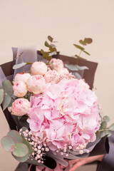 Stylish fllowers bouquet with pink hydrangea and roses in contrasting black wrapping paper. Designer flower bouquet from a florist