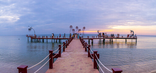 Sunset in Phu Quoc beach with nice view. Tourists, sunbeds and umbrellas on beautiful day in Sanato beach.