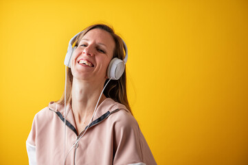Cheerful young woman laughing joyfully while listening to music