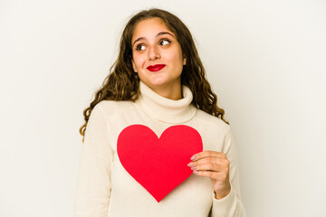 Young caucasian woman holding a heart valentines day shape isolated dreaming of achieving goals and purposes