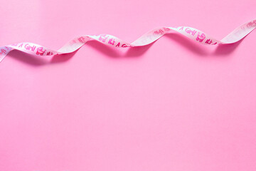 Fondo rosa con espacio libre para mensaje o foto del bebé. Cinta rosa decorativa.