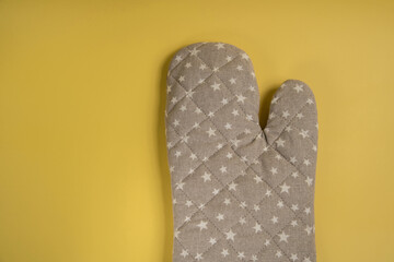 Kitchen glove decorated with a pattern of stars on a yellow