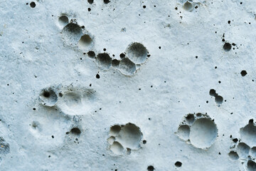 Cement, concrete, textured white surface with holes background.
