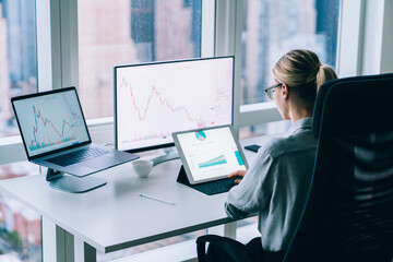 Faceless woman analyzing charts in office
