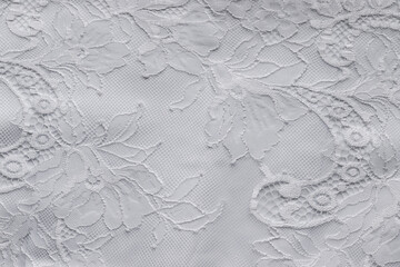 Delicate white lace on a silk fabric backing. Bridal wedding dress textile