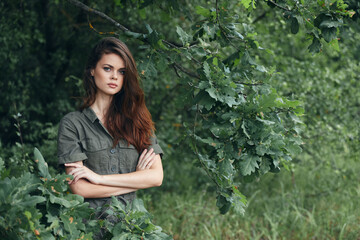 woman in the forest Looks forward with folded hands in front of him 