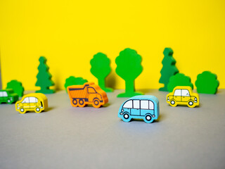wooden cars on a yellow-gray background.