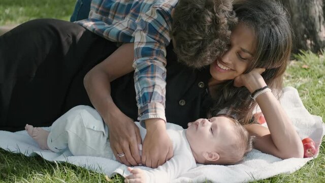 Happy african american family young adult mum and cute mixed race child kid laughing cuddle having fun sit in the park enjoy sweet moment play together