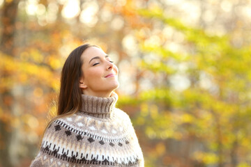 Relaxed woman breathing fresh air in a park in winter