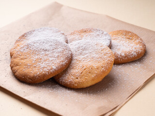 Delicious homemade shortbread cookies, in warm brown tones, close-up. Cookies in powdered sugar on a paper napkin
