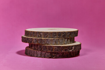 Round wooden saw cut cylinder shape on color abstract background. Minimal box and geometric podium. Scene with geometrical forms. Empty showcase for eco cosmetic product presentation