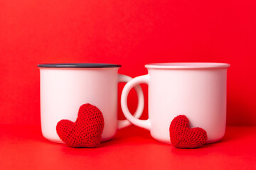 Couple white cups of coffee with two knittled hearts on red background, Dating on valentine's day,...