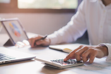 close up hands of accountant calculating tax refund using calculator