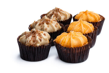 Mini sponge cakes with orange and caramel buttercream topped isolated on white