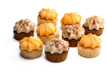 Mini sponge cakes with orange and caramel buttercream topped isolated on white