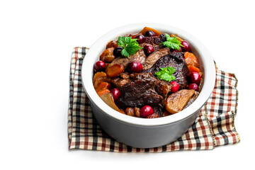 Braised beef with cranberries in clay bowl isolated on white
