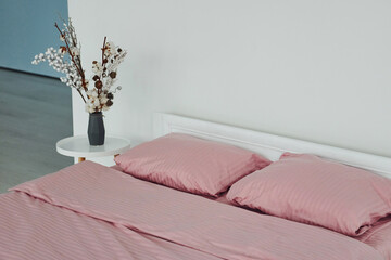 Pink colored bed. Interior and design of beautiful modern bedroom at daytime