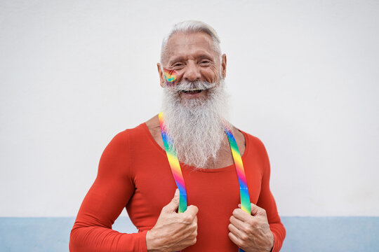 Portrait of hipster senior man laughing at gay pride parade - Concept of lgbt and homosexual love