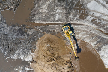 Yellow excavator digger working. Excavator digging sand, ground from water. Industrial aerial drone view. © Chawran