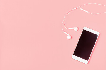 Mockup and flat lay template with white color phone smartphone and headphones on pink background with copy space.