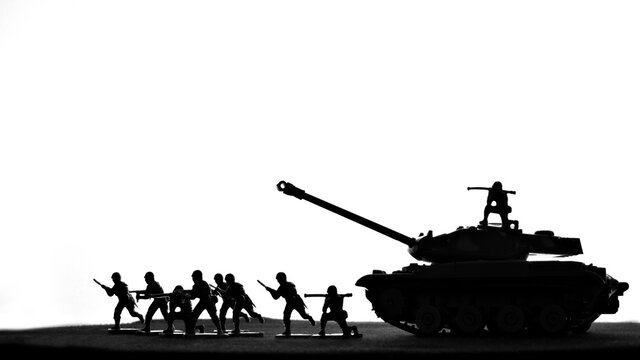 A silhouette image of toy soldiers and tank in a war battle scene.  - Powered by Adobe